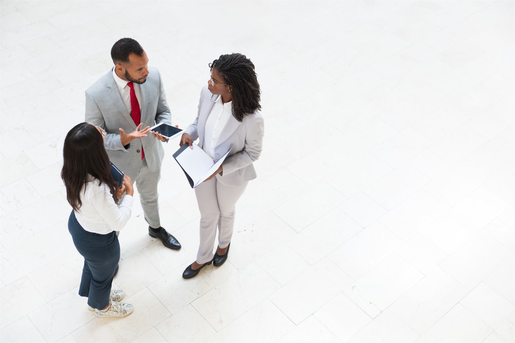 Three consultants in conversation in a bright office lobby